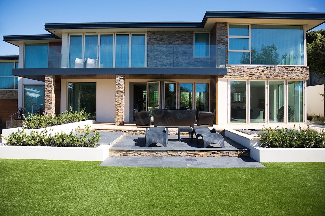 Front Elevation of Modern Designed Home with a prominent stacked stone and glass facade